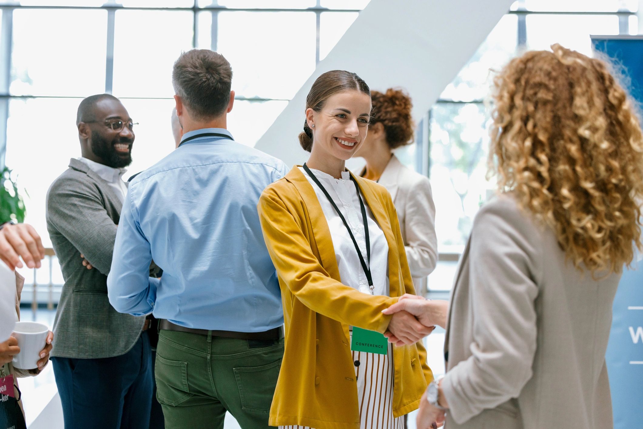 Professionals greeting with a handshake at a conference
